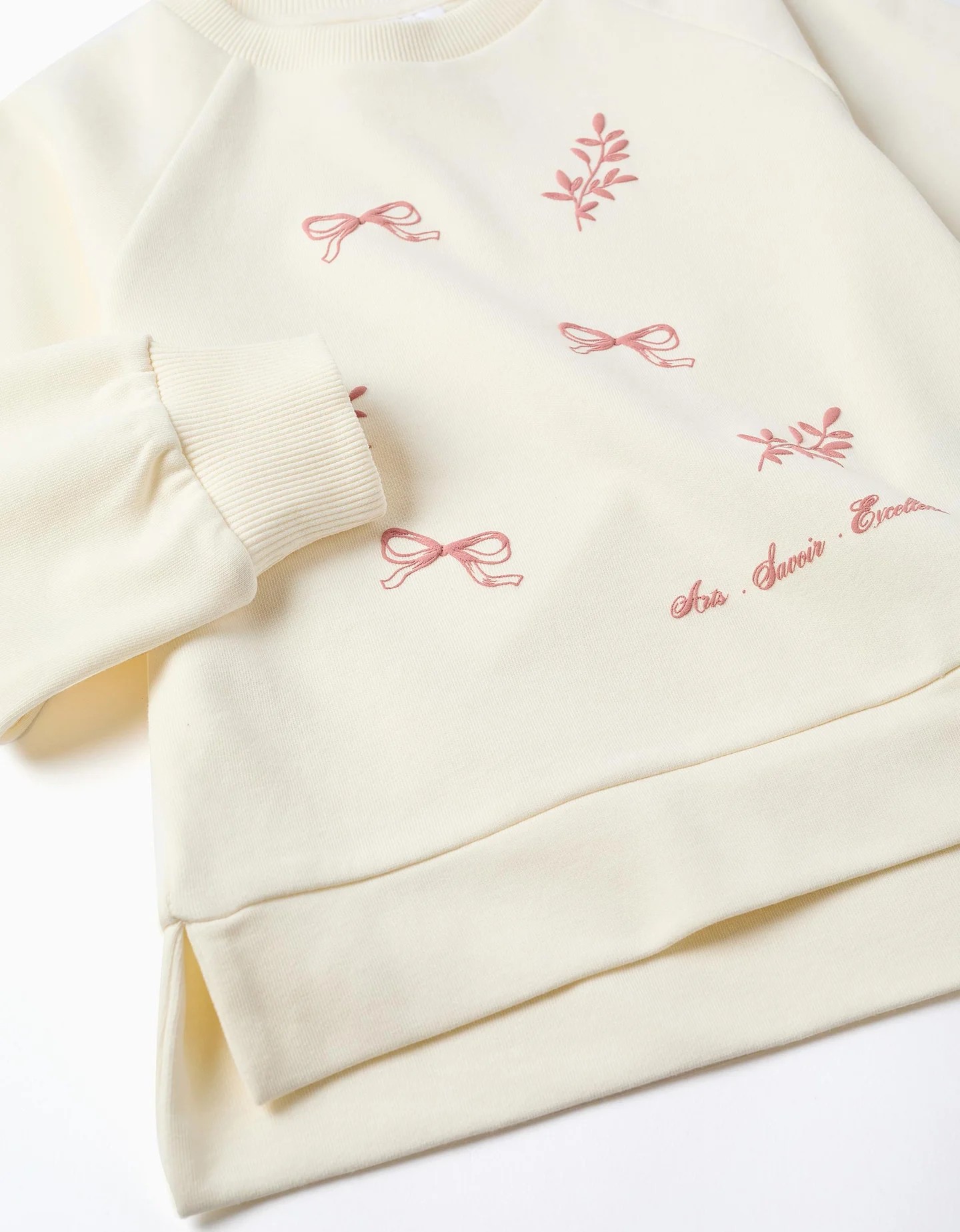 Sudadera niña blanca crema estampado relieve lazos hojas rosas texto Arts Savoir Excellent mangas abullonadas raglán puños acanalados dobladillo asimétrico aberturas laterales algodón
