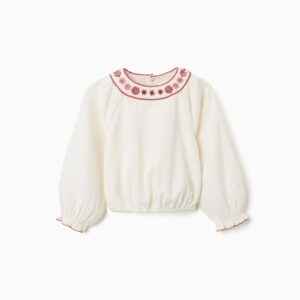 Blusa niña blanco roto cuello redondo bordado floral rojo rosa azul ribete festoneado mangas abullonadas puños elásticos bajo elástico botones madera espalda