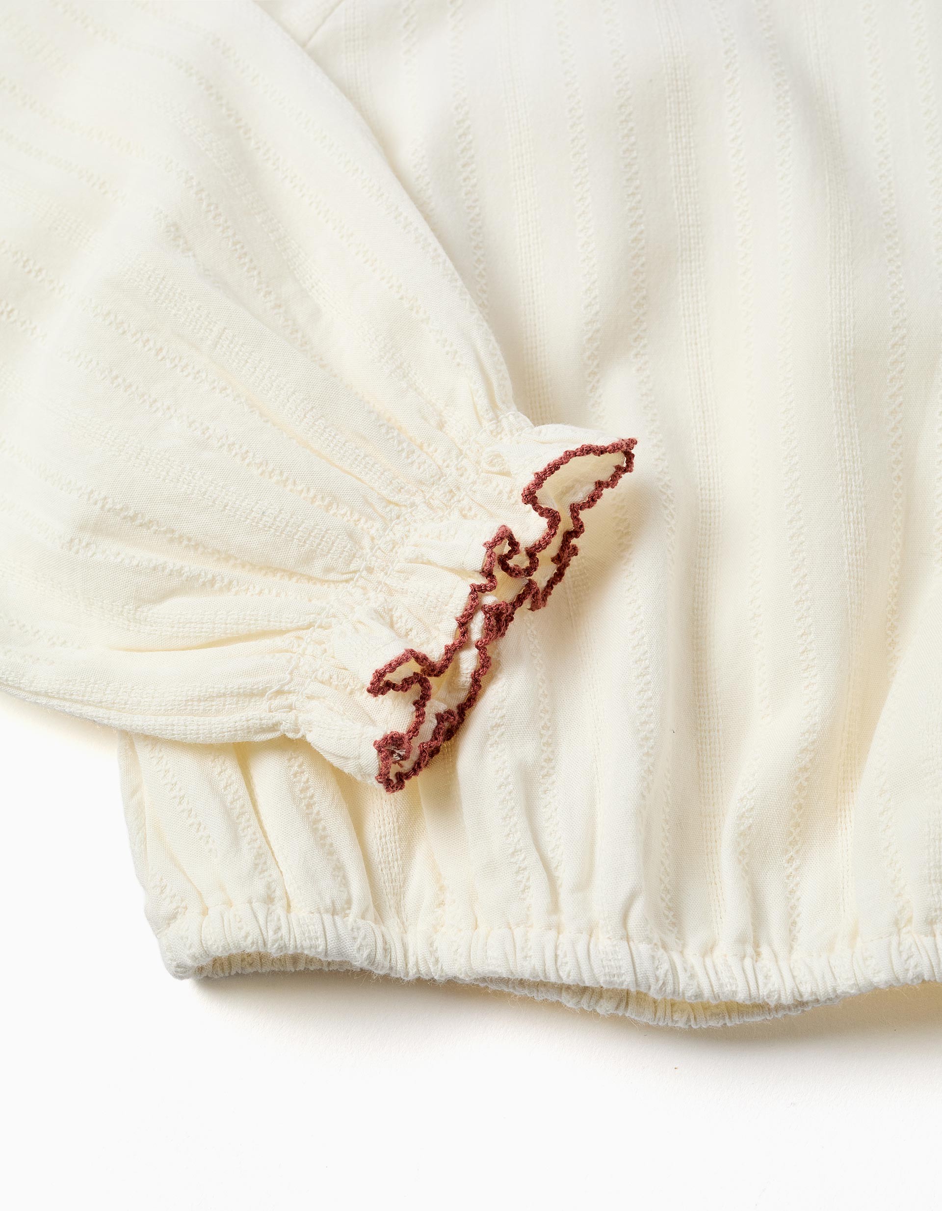 Blusa niña blanco roto cuello redondo bordado floral rojo rosa azul ribete festoneado mangas abullonadas puños elásticos bajo elástico botones madera espalda