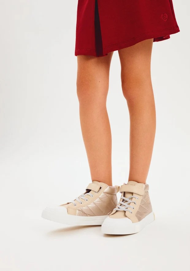 Zapatillas altas niña Conguitos doradas beige metalizado acolchadas caña alta cordones elásticos blancos velcro puntera goma blanca logo Conguitos suela flexible tirador trasero