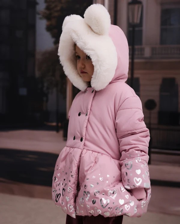 Niña vistiendo abrigo acolchado rosa con capucha de pelo y orejitas Niña vistiendo abrigo acolchado rosa con capucha de pelo y orejitas